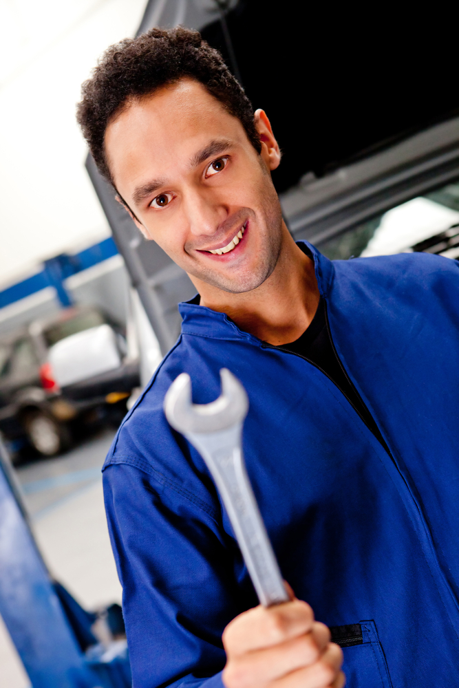 Male mechanic with a wrench at a car garage